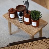 Bougies, diffuseur et flacon La Rêveuse sur un tabouret, avec une succulente