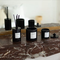 Bougies et diffuseur Le Raffiné posés sur un marbre